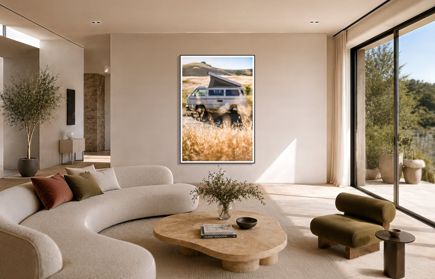 California Classic by Dylan Ozanich in a Black frame, above a cream curved sofa in a sunlit room with olive velvet seating