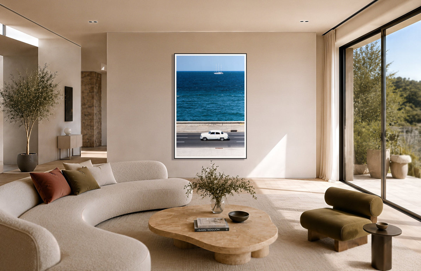 Melacon by Dylan Ozanich in a Black frame, above a cream curved sofa in a sunlit room with olive velvet seating