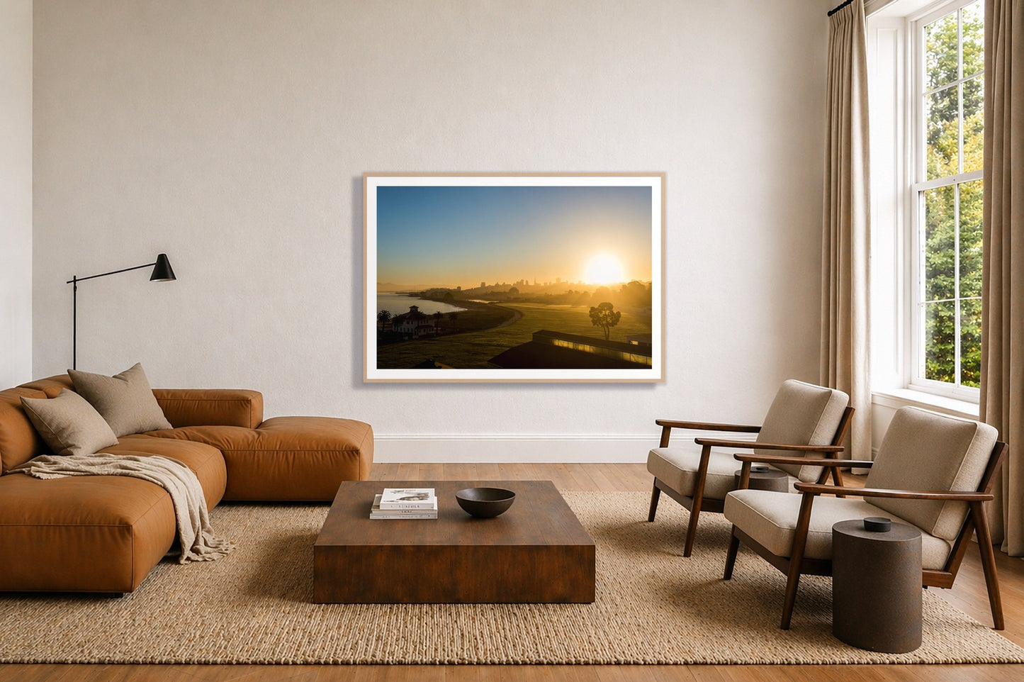 San Francisco At Dawn by Dylan Ozanich in an Oak frame, above a tan modular leather sofa in a minimal, sunlit living room