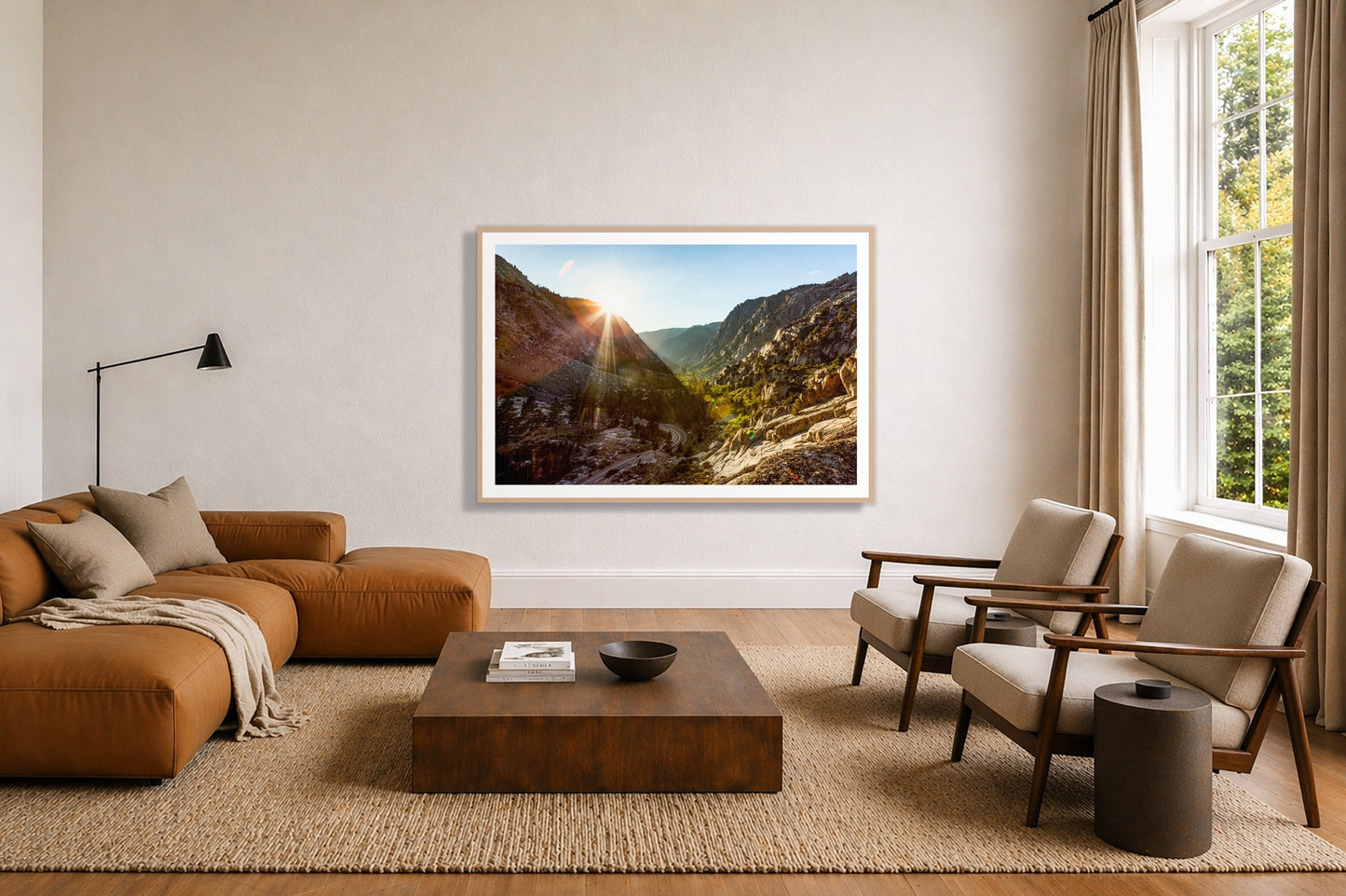 Sierra Nevadas by Dylan Ozanich in an Oak frame, above a tan modular leather sofa in a minimal, sunlit living room