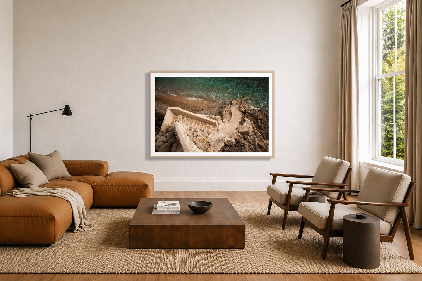 Stairs From Monaco by Dylan Ozanich in an Oak frame, above a tan modular leather sofa in a minimal, sunlit living room