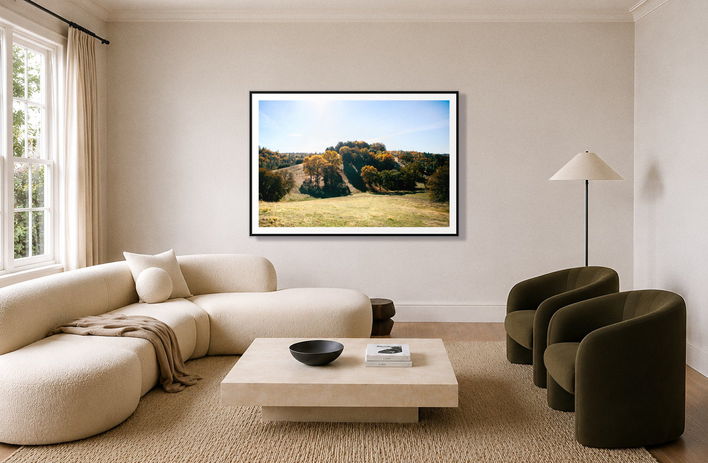 Where IGrew Up by Dylan Ozanich in a Black frame, above a cream curved sofa in a living room with olive velvet armchairs