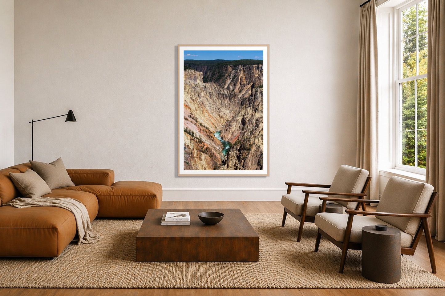 Yellowstone Canyon by Dylan Ozanich in an Oak frame, above a tan modular leather sofa in a minimal, sunlit living room
