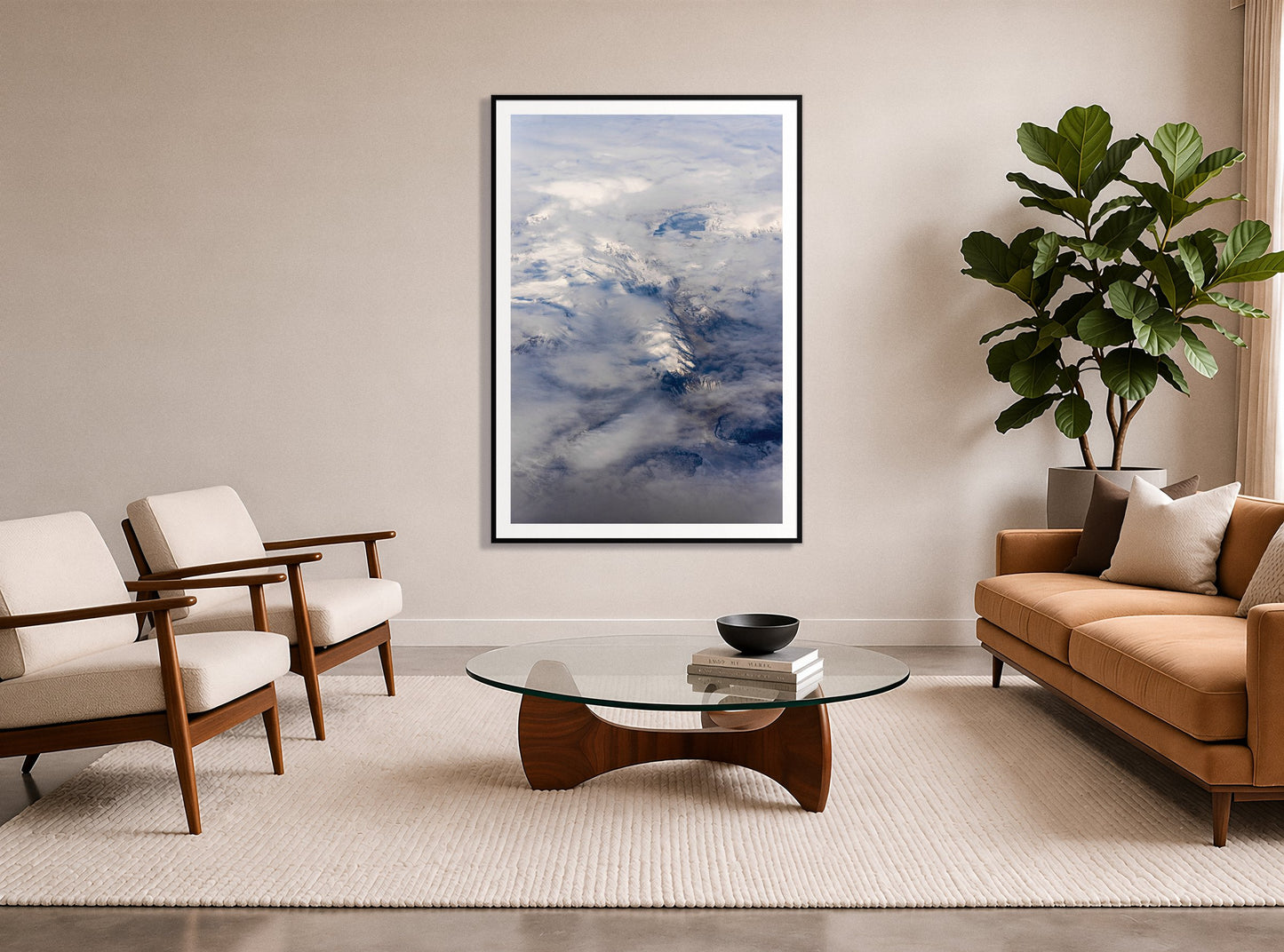Above It All by Dylan Ozanich in a Black frame, in a midcentury living room with a tan leather sofa and fiddle-leaf fig
