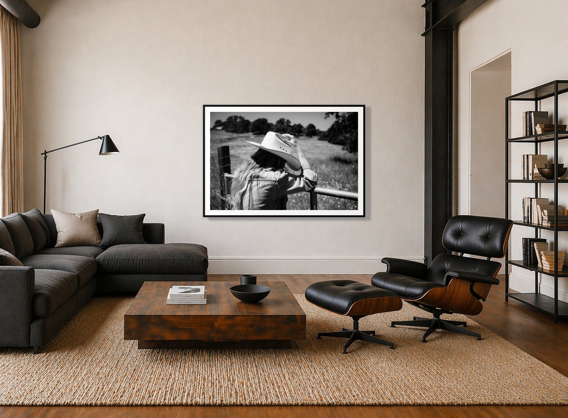 Branded by Dylan Ozanich in a Black frame, above a dark sectional in a loft with a black leather lounge chair