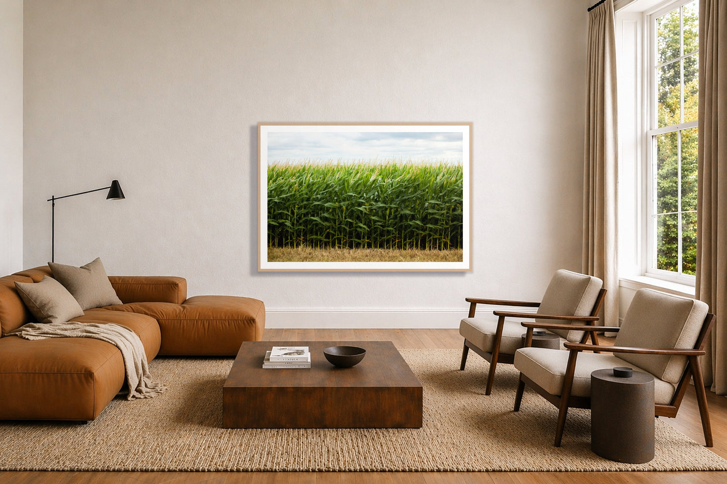 Corn Crop by Dylan Ozanich in an Oak frame, above a tan modular leather sofa in a minimal, sunlit living room