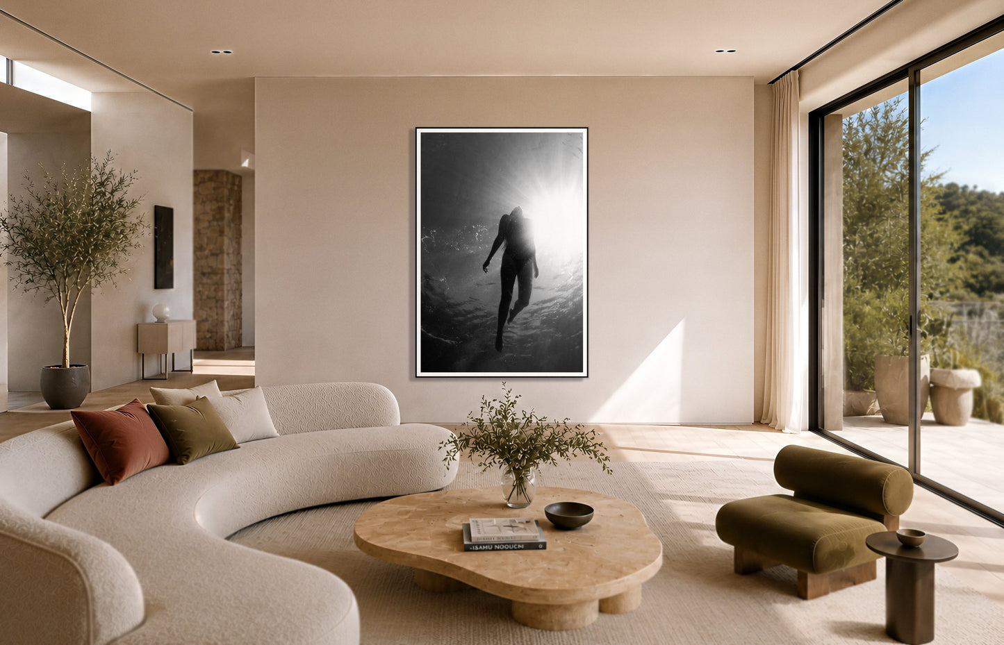 Depth by Dylan Ozanich in a Black frame, above a cream curved sofa in a sunlit room with olive velvet seating