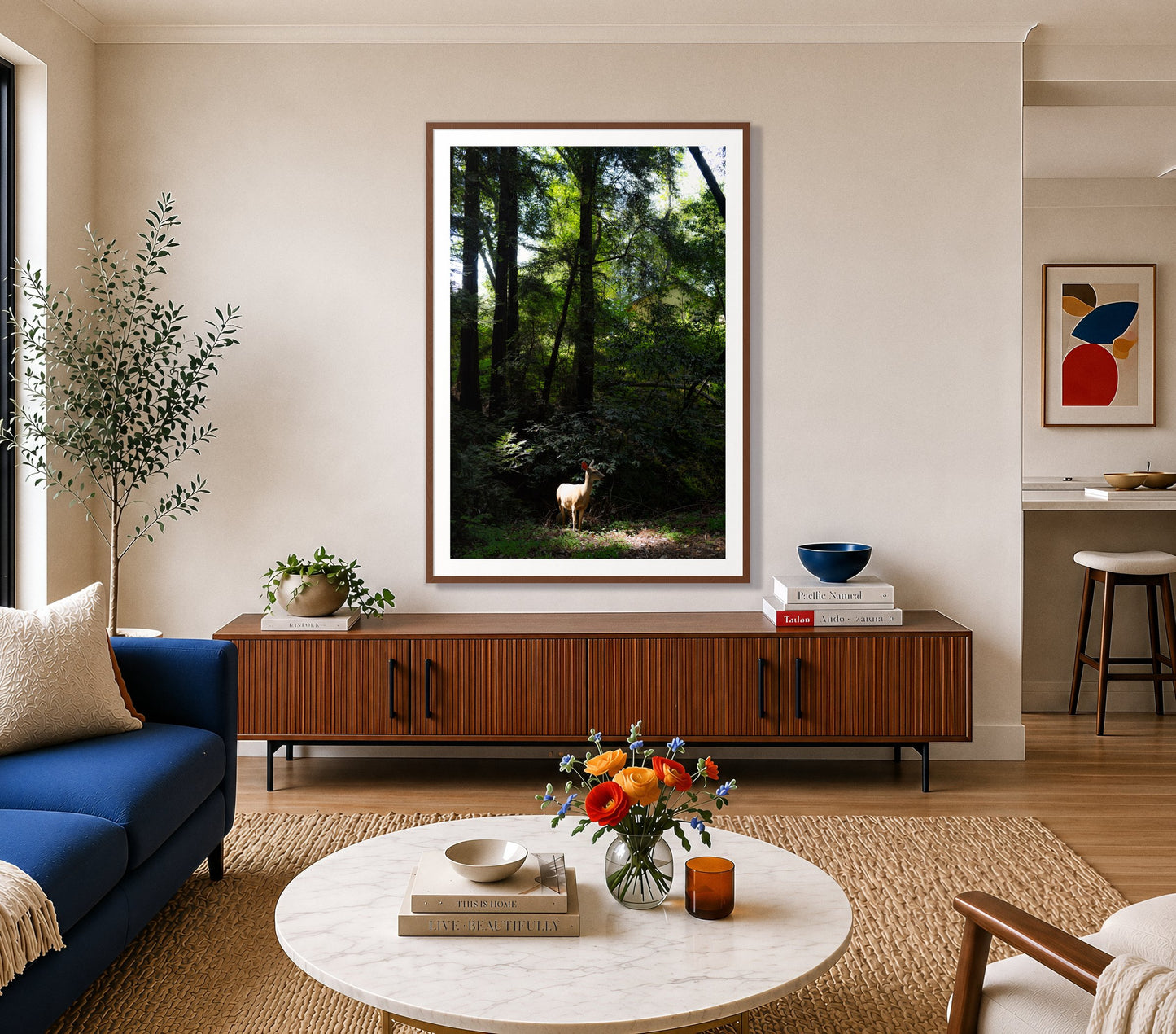 Doe by Dylan Ozanich in a Walnut frame, above a walnut credenza in a bright living room with a blue sofa
