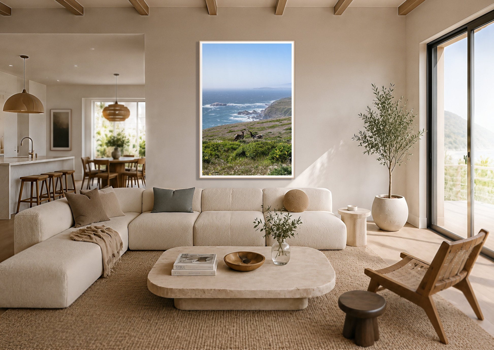 Elk On The Bluff by Dylan Ozanich in an Oak frame, above a cream sectional in a coastal living room with an ocean view