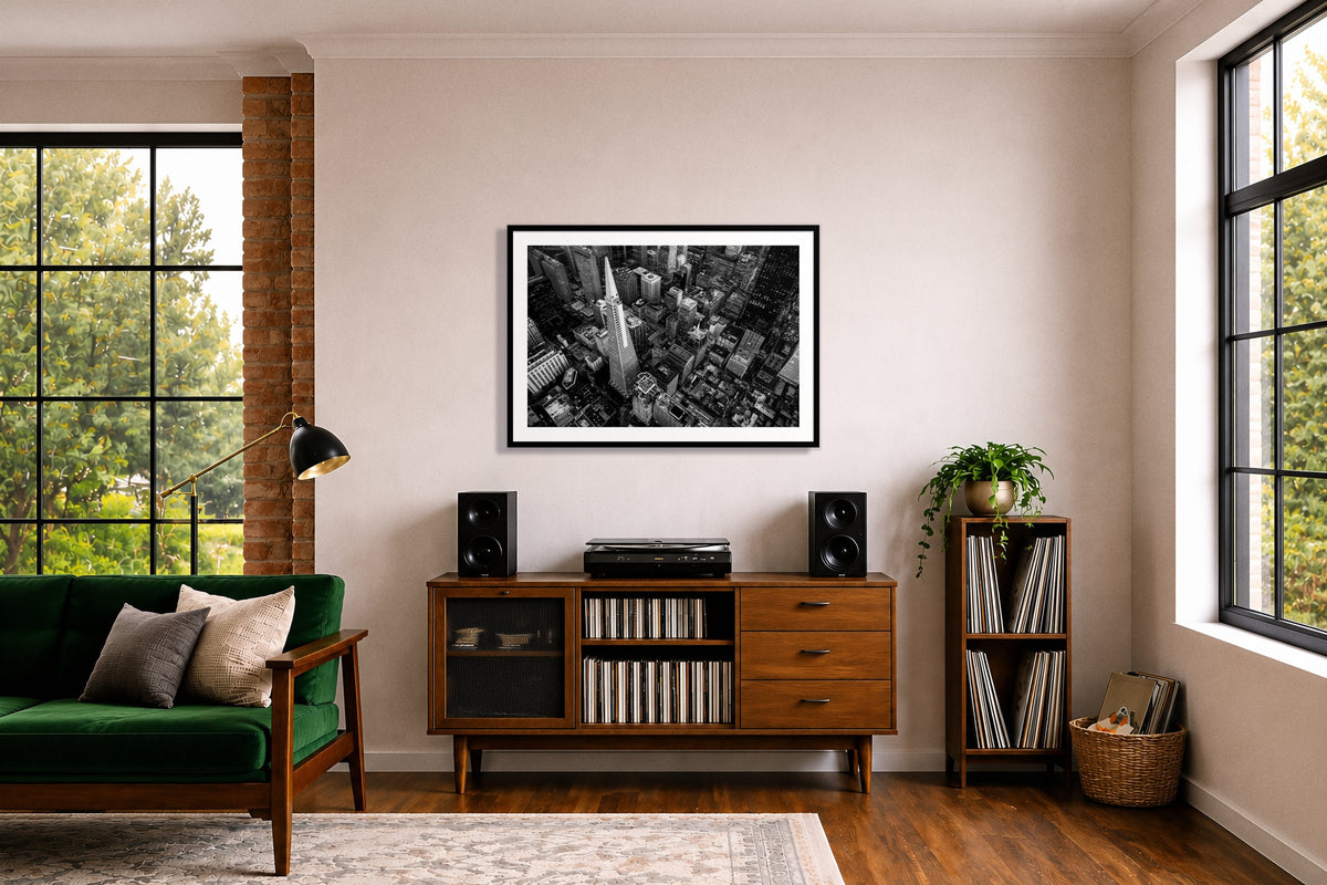 First Impressions by Dylan Ozanich in a Black frame, above a record credenza in a listening room with a green velvet sofa