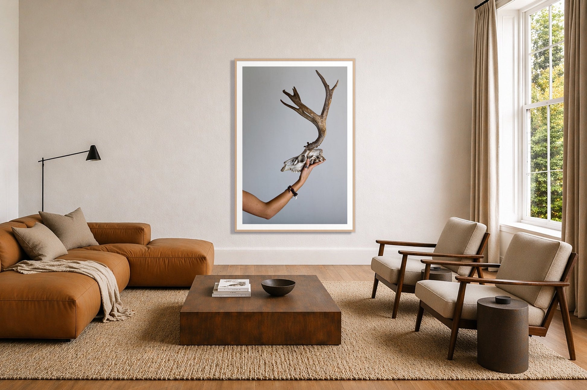 First Kill by Dylan Ozanich in an Oak frame, above a tan modular leather sofa in a minimal, sunlit living room