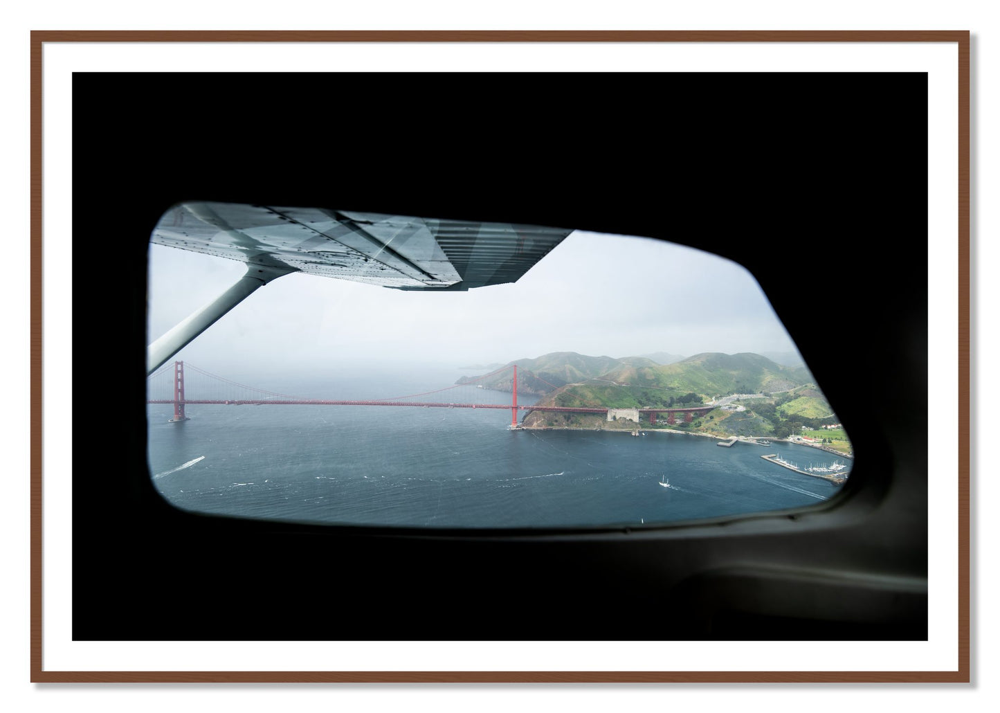 Framed photograph of Flying Over The Gate by Dylan Ozanich, Walnut frame, Borders