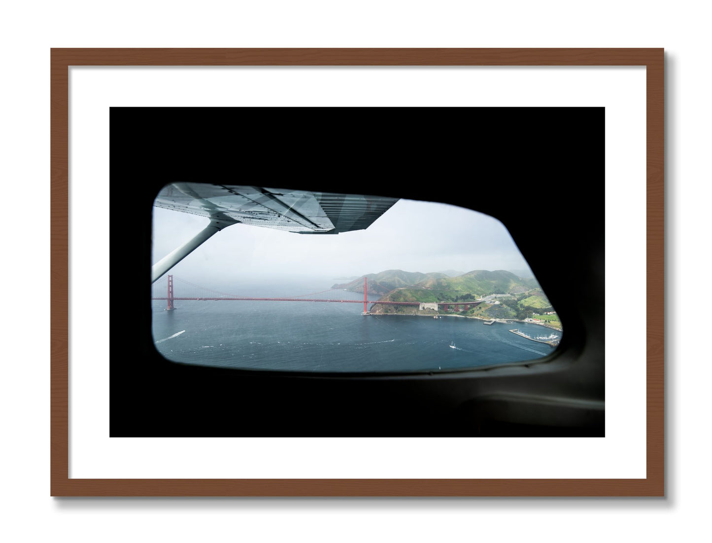 Framed photograph of Flying Over The Gate by Dylan Ozanich, Walnut frame, Borders
