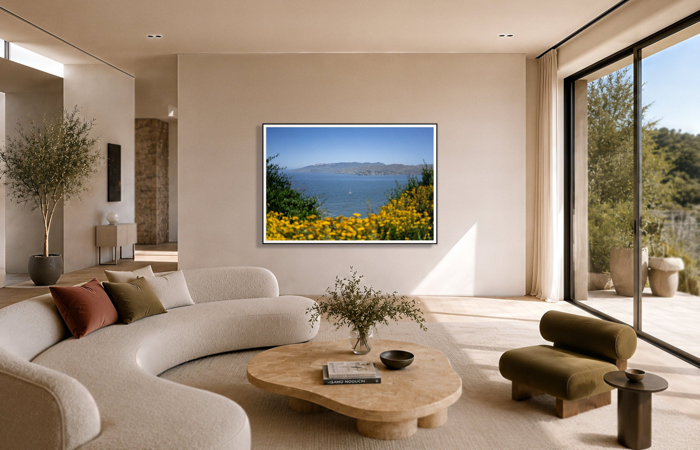 Golden Bay by Dylan Ozanich in a Black frame, above a cream curved sofa in a sunlit room with olive velvet seating