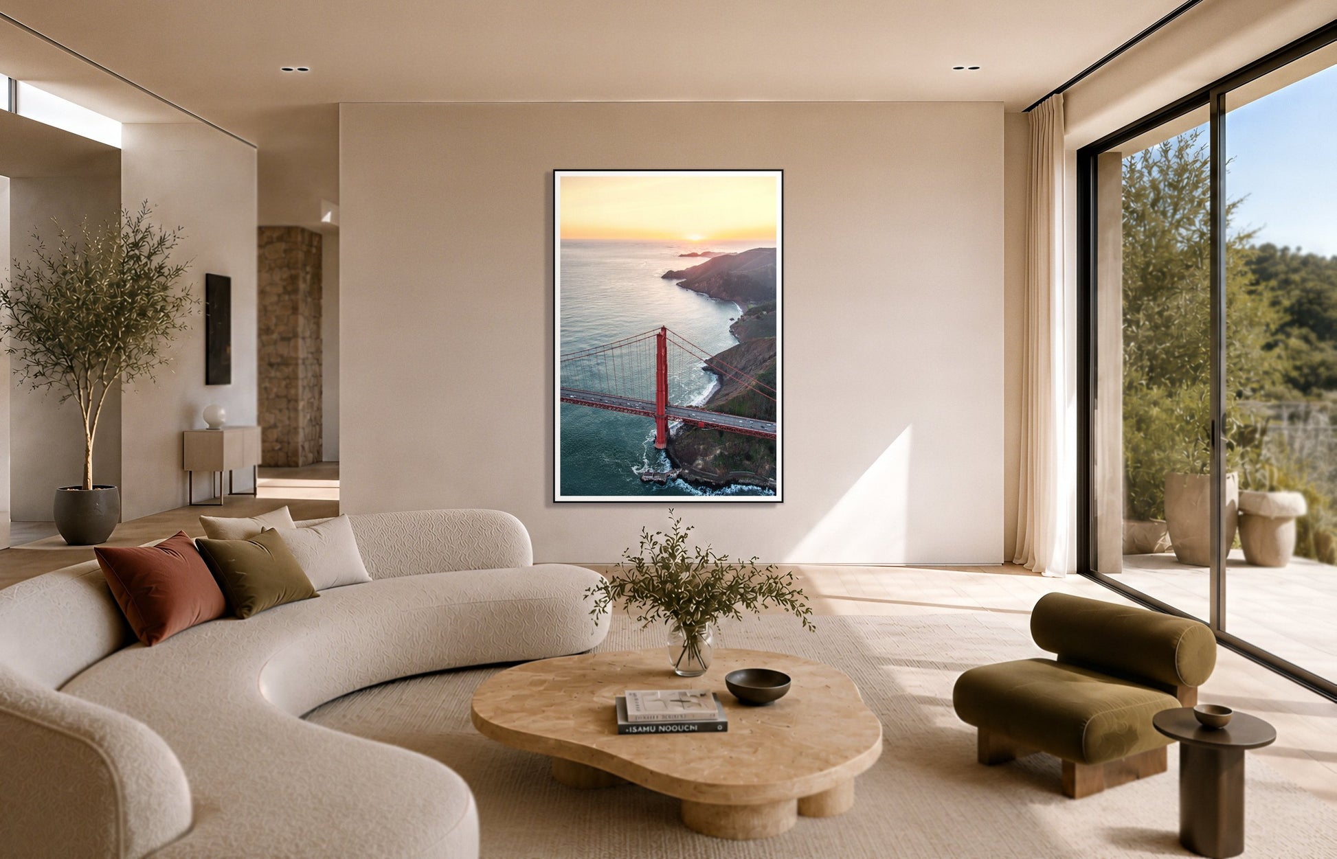 Golden Gate At Dusk by Dylan Ozanich in a Black frame, above a cream curved sofa in a sunlit room with olive velvet seating