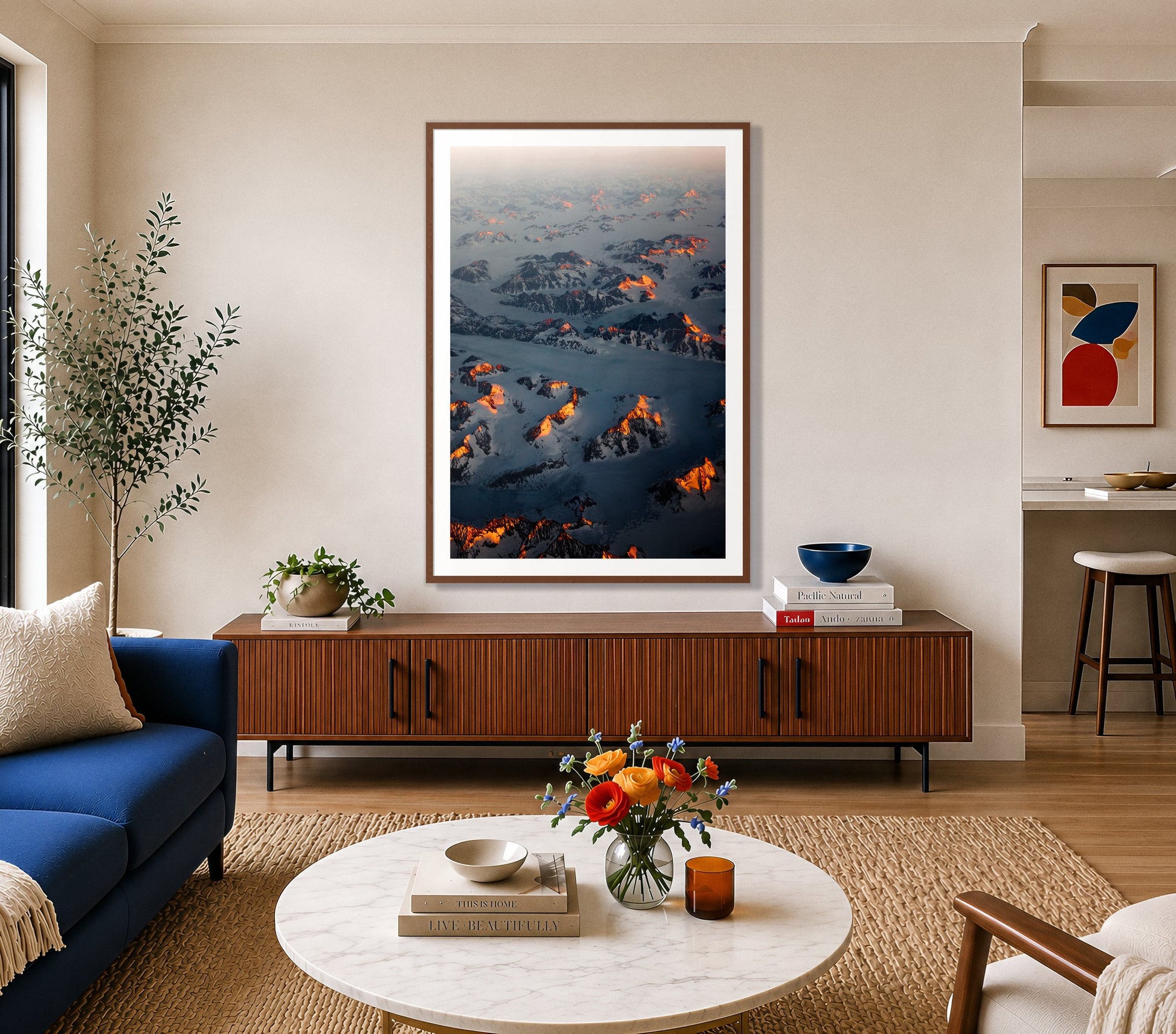 Greenland Light by Dylan Ozanich in a Walnut frame, above a walnut credenza in a bright living room with a blue sofa