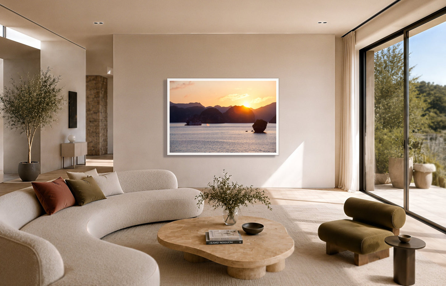 Ha Long Bay by Dylan Ozanich in a White frame, above a cream curved sofa in a sunlit room with olive velvet seating