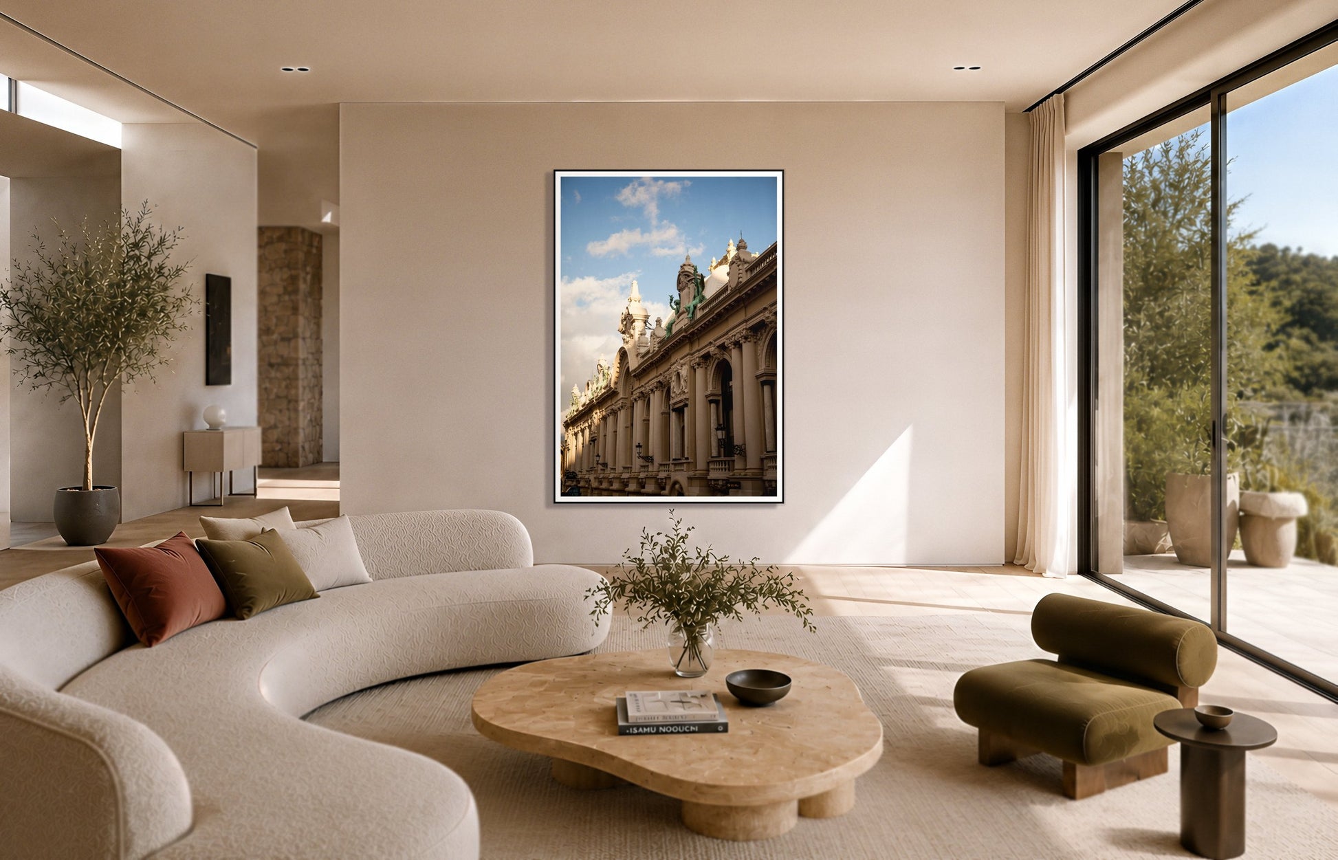Monoco by Dylan Ozanich in a Black frame, above a cream curved sofa in a sunlit room with olive velvet seating