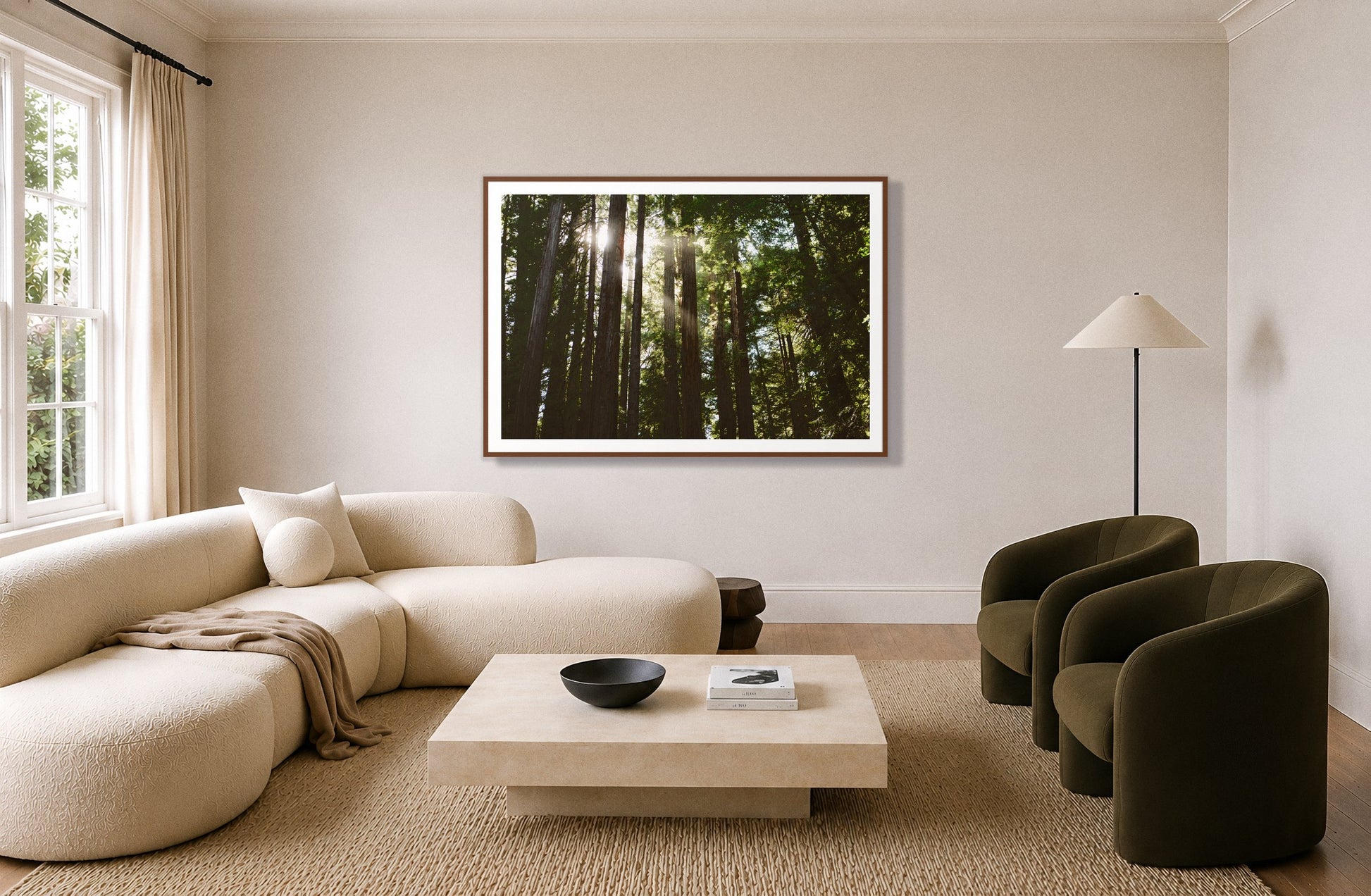 Muir Woods by Dylan Ozanich in a Walnut frame, above a cream curved sofa in a living room with olive velvet armchairs