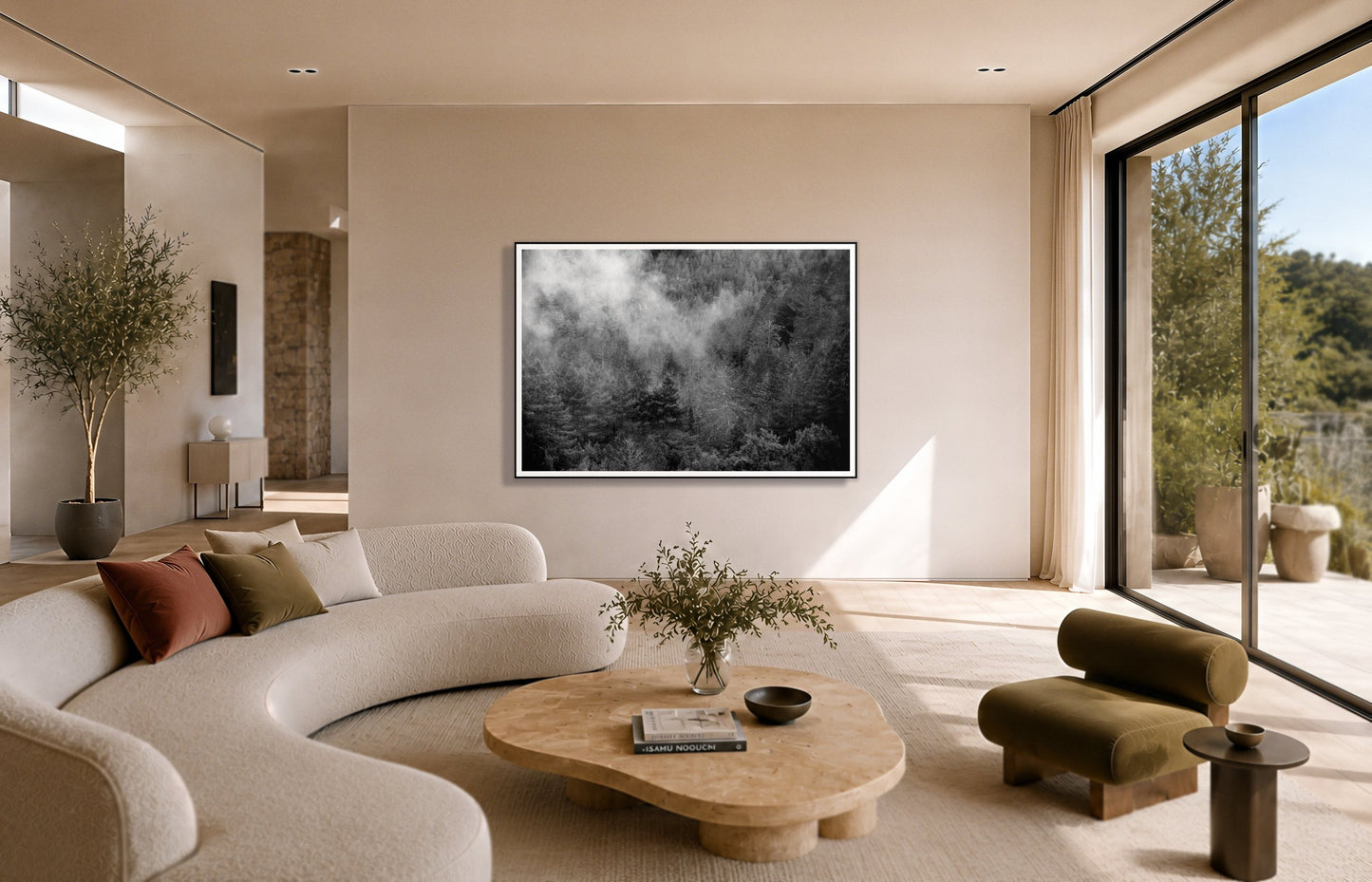 Muir by Dylan Ozanich in a Black frame, above a cream curved sofa in a sunlit room with olive velvet seating