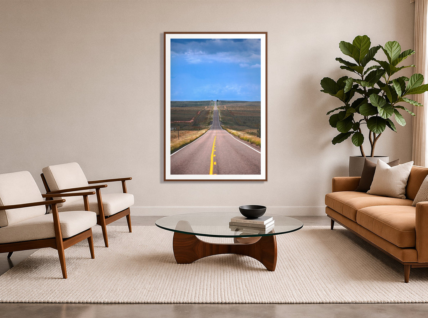 Over The Hill by Dylan Ozanich in a Walnut frame, in a midcentury living room with a tan leather sofa and fiddle-leaf fig