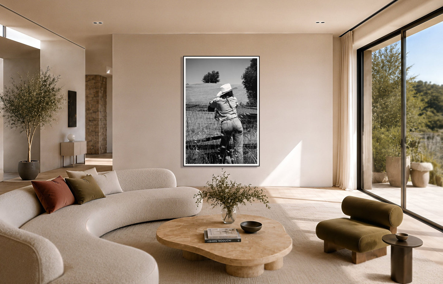 Ranch Days by Dylan Ozanich in a Black frame, above a cream curved sofa in a sunlit room with olive velvet seating