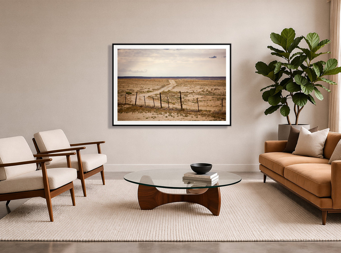 Road To Nowhere by Dylan Ozanich in a Black frame, in a midcentury living room with a tan leather sofa and fiddle-leaf fig