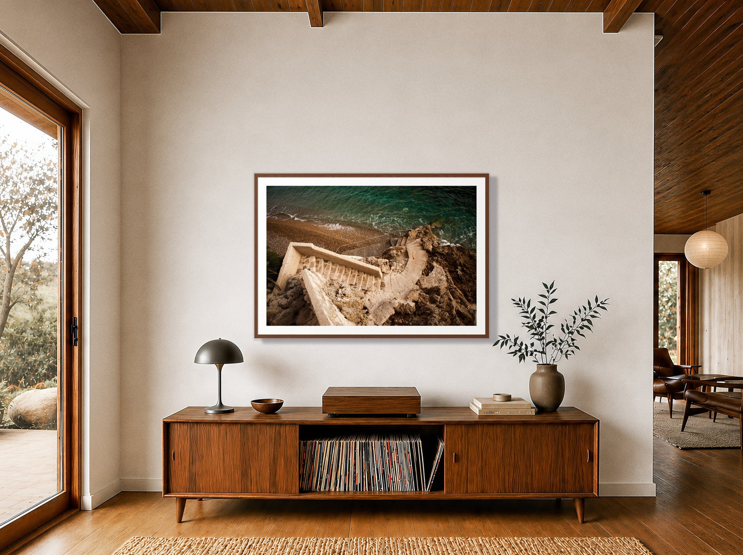 Stairs From Monaco by Dylan Ozanich in a Walnut frame, above a walnut record credenza in a wood-beamed midcentury room
