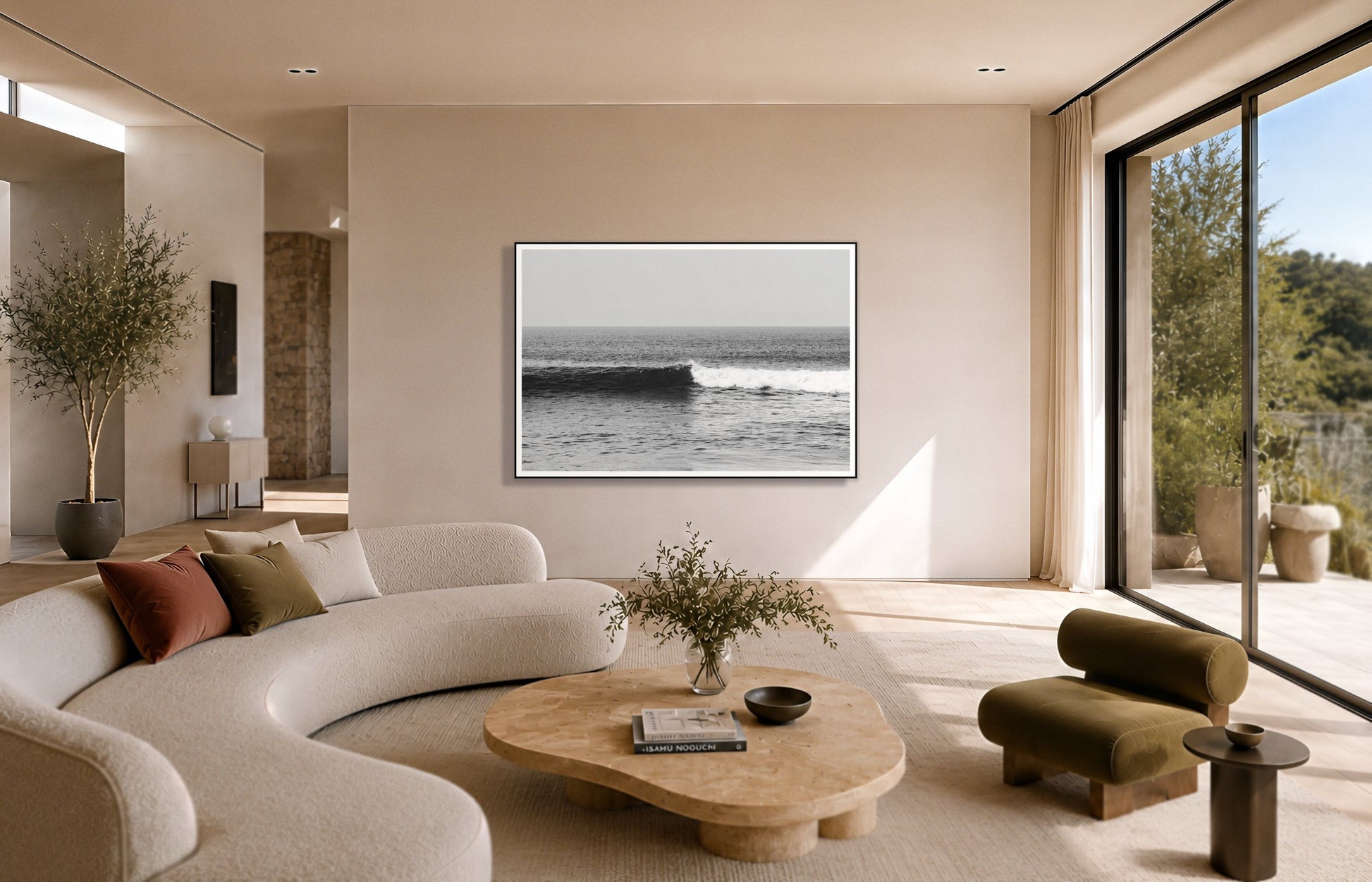The Wave by Dylan Ozanich in a Black frame, above a cream curved sofa in a sunlit room with olive velvet seating