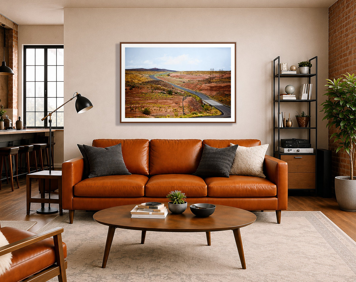 We Rode by Dylan Ozanich in a Walnut frame, above a cognac leather sofa in a brick loft