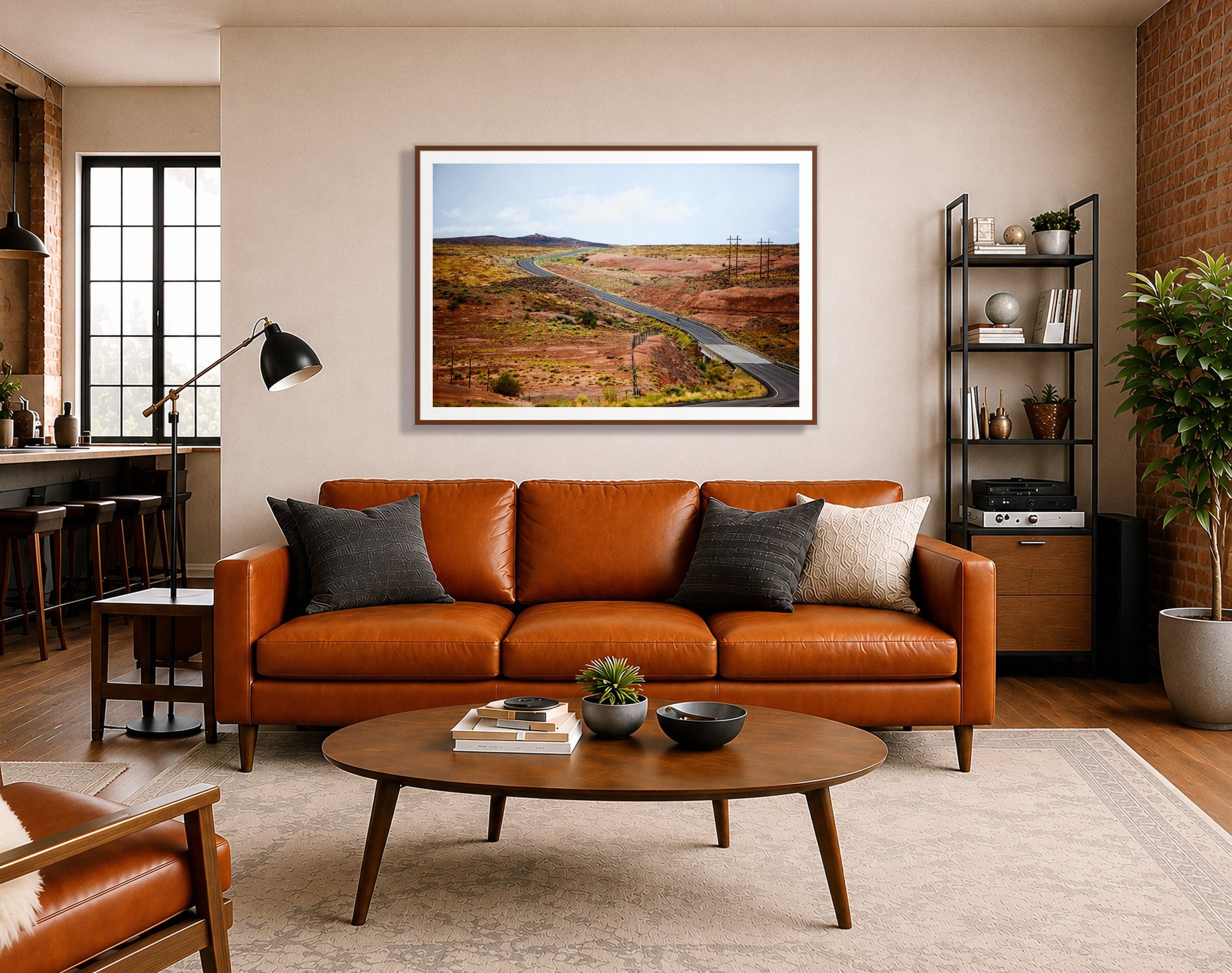 We Rode by Dylan Ozanich in a Walnut frame, above a cognac leather sofa in a brick loft
