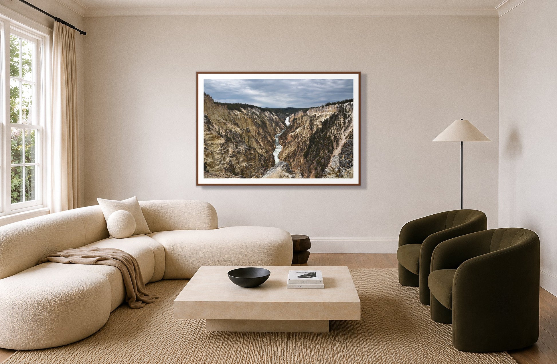 Wyoming by Dylan Ozanich in a Walnut frame, above a cream curved sofa in a living room with olive velvet armchairs